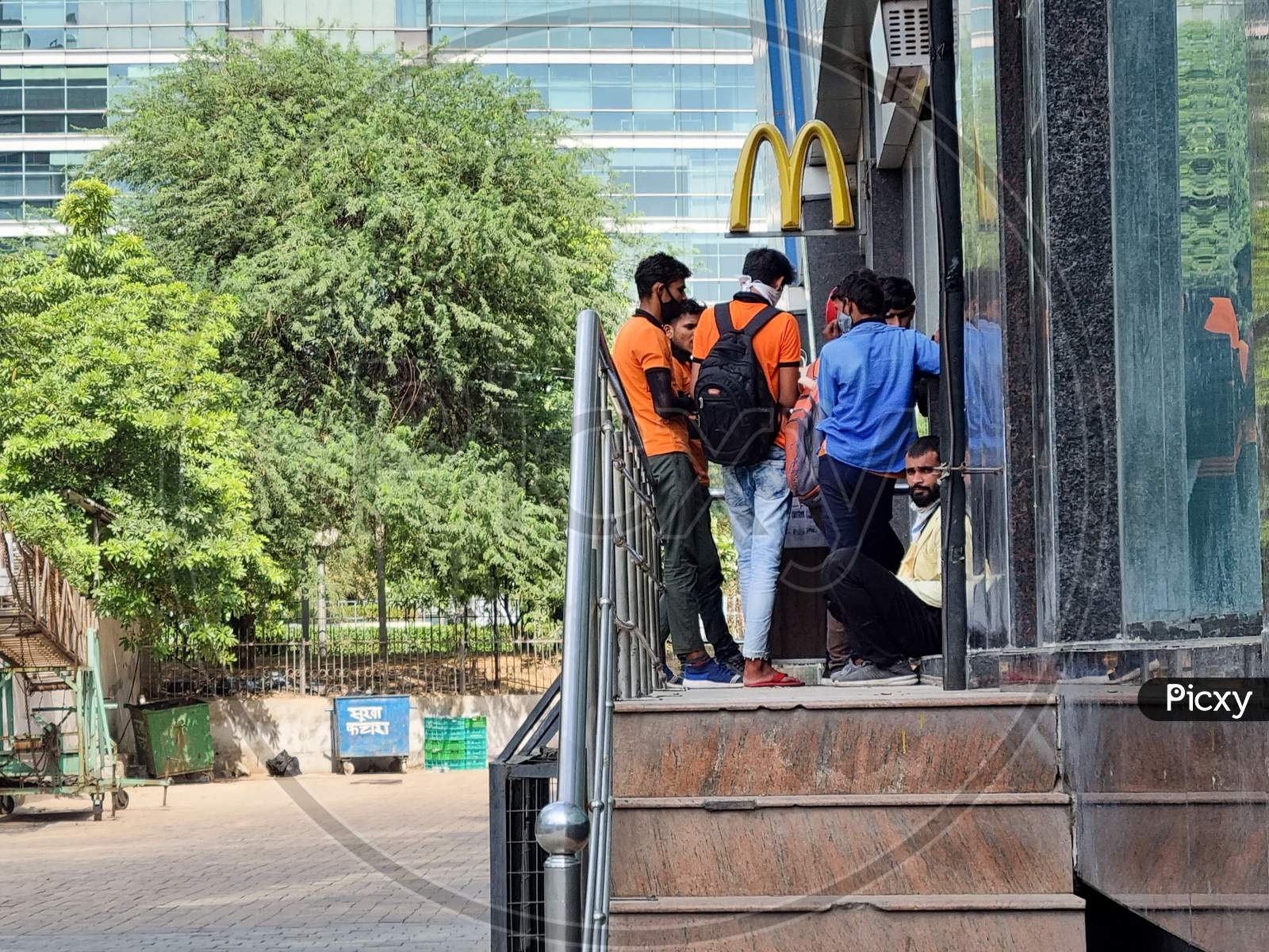 Delivery Boys Riders From Companies Like Swiggy Shadowfax Zomato Standing At A Mcdonalds Takeaway For Online Food Delivery By E-Commerce App Unicorns