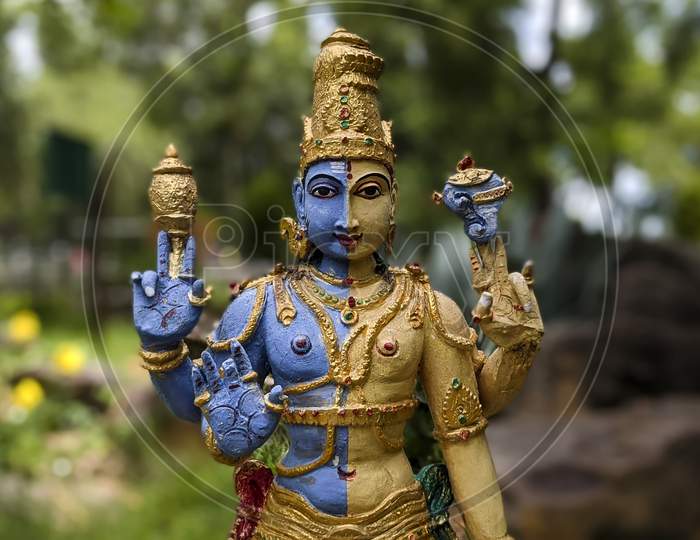 Close Front View of Lord Shiva-Parvathi Ardanarishwara Avatar idol isolated in Natural Rock Garden in Tirumala