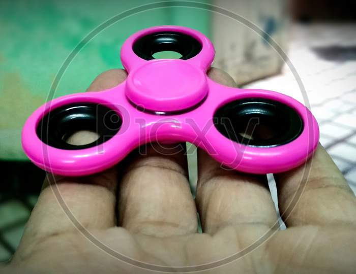 Young Man Playing With A Fidget Spinner, Focus On Spinner