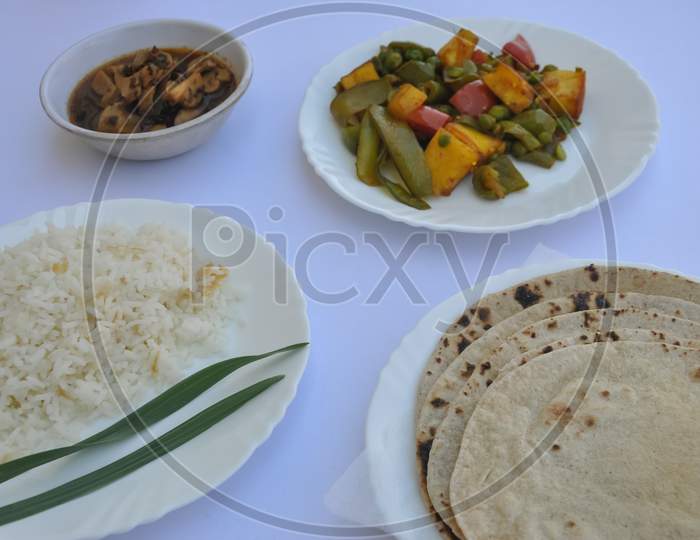 Closeup of matar paneer veg, mashroom soup, roti (chapati) and rice (Indian food) isolated over white background