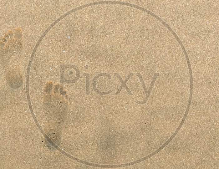 Footprints of a human in the Seashore sand with a selective focus on footprints . Copy space. Aerial .Vacation . Resort