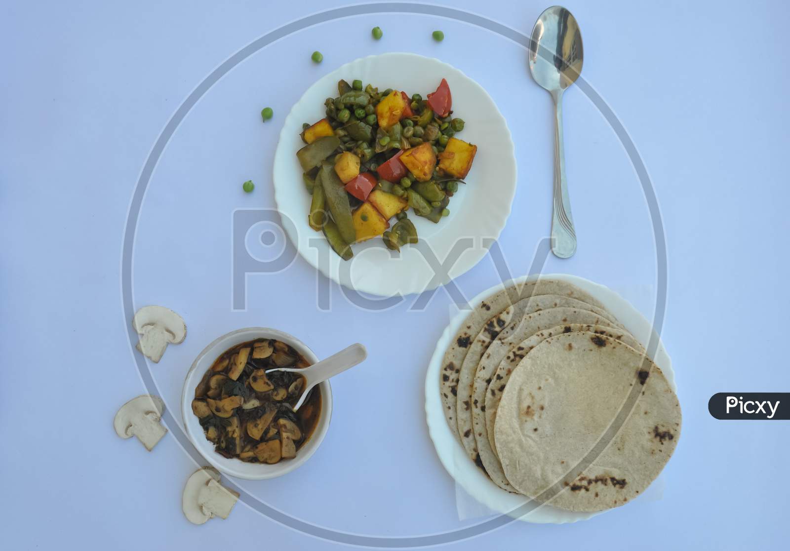 Overhead view of matar paneer veg, mashroom soup and roti (Indian food) over white background, with copy space