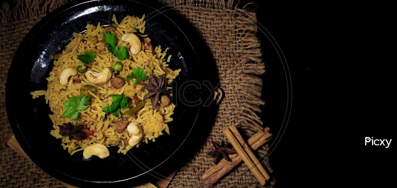 Delicious Homemade Pulao or vegetable briyani or Vegetable Rice made with Basmati rice, vegetable and spices isolated in a Black dark background with copy space.