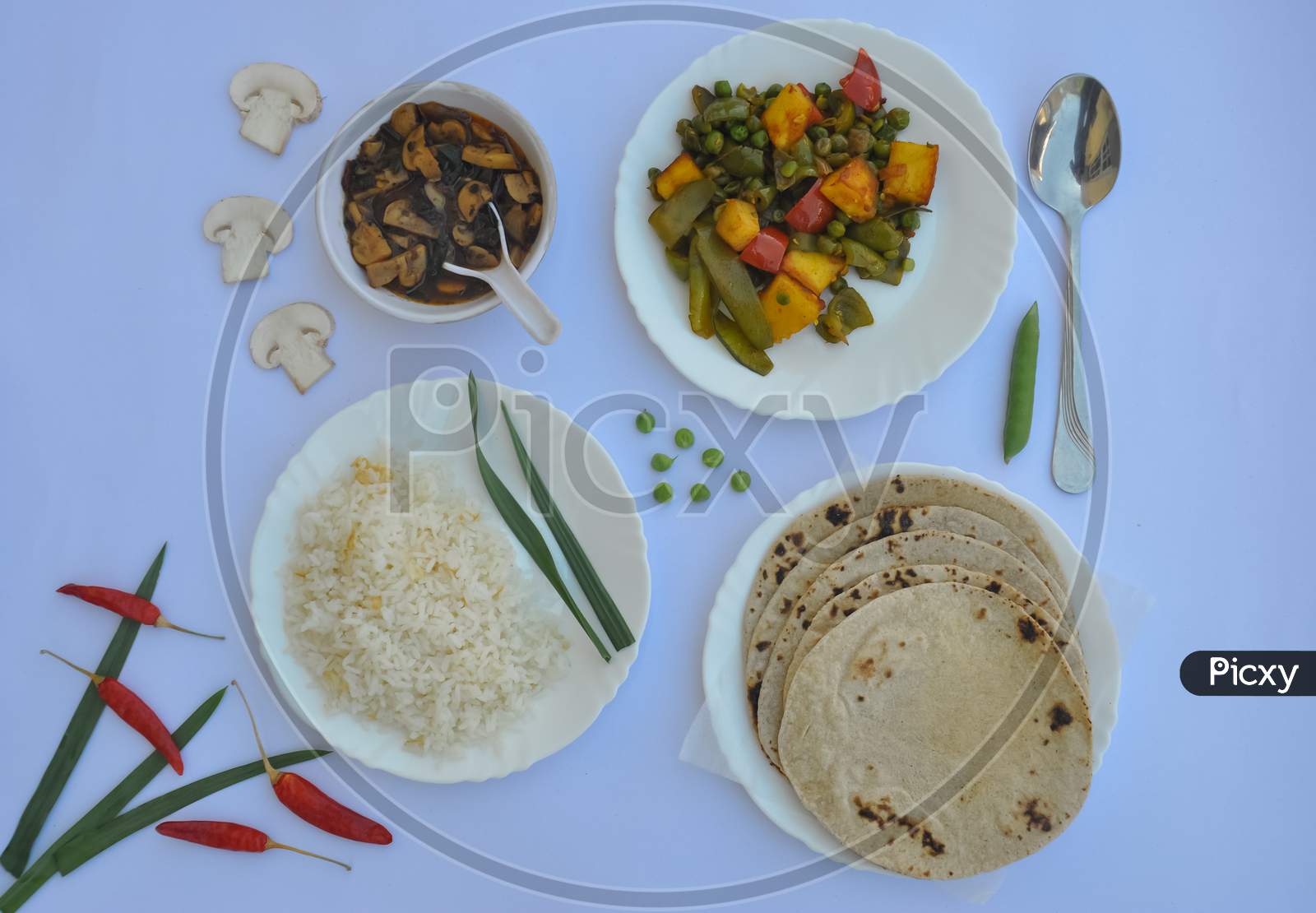 Top view of matar paneer veg, mashroom soup, roti (chapati) and rice (Indian food) isolated over white background