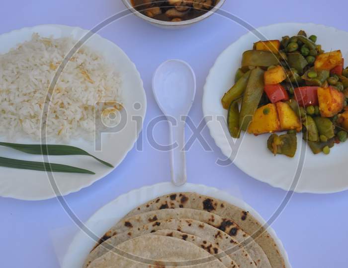 Closeup of matar paneer veg, mashroom soup, roti (chapati) and rice (Indian food) isolated over white background