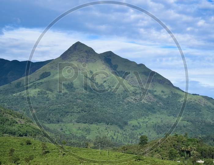 Landscape Oriented Wallpaper Poster Background Of Highest Mountain In Wayanad Chembra Peak Hills On A Hazy Day In Meppadi.
