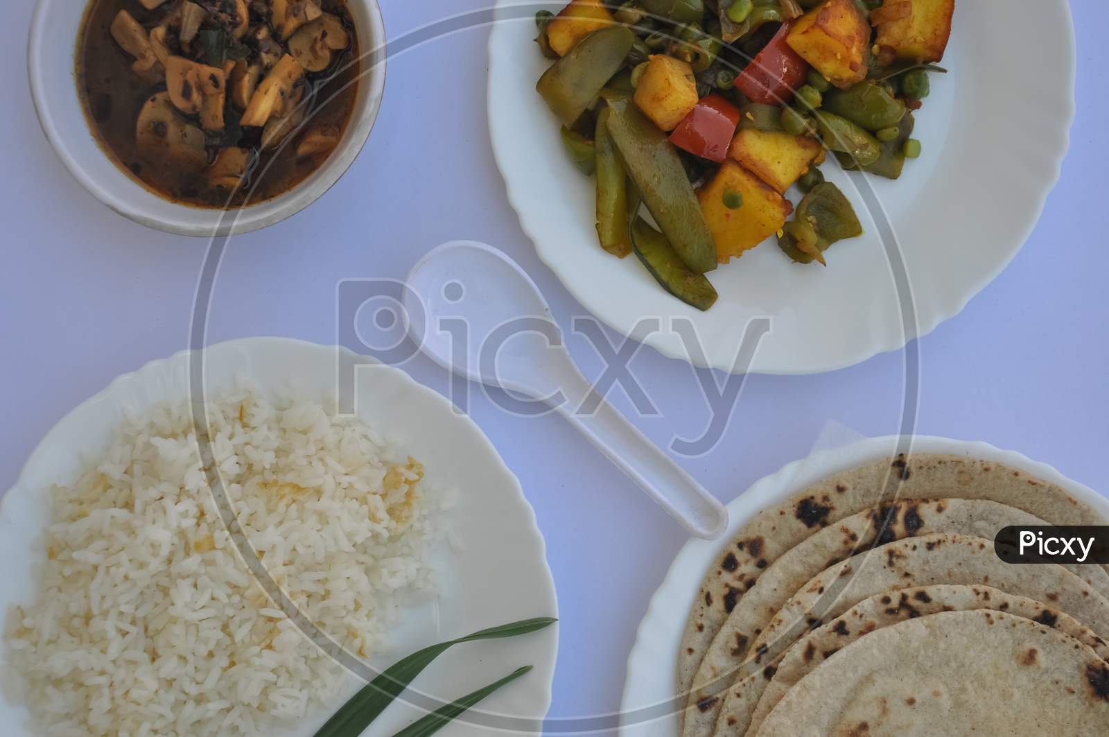 Top view of matar paneer veg, mashroom soup, roti (chapati) and rice (Indian food) isolated over white background