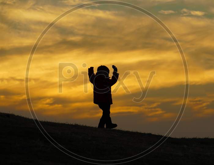 Boy Standing In The Twilight Of The Hill