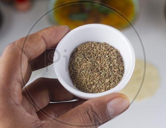 A Person Holding A Celery Seed Bowl In Hand Isolated On Light Background.