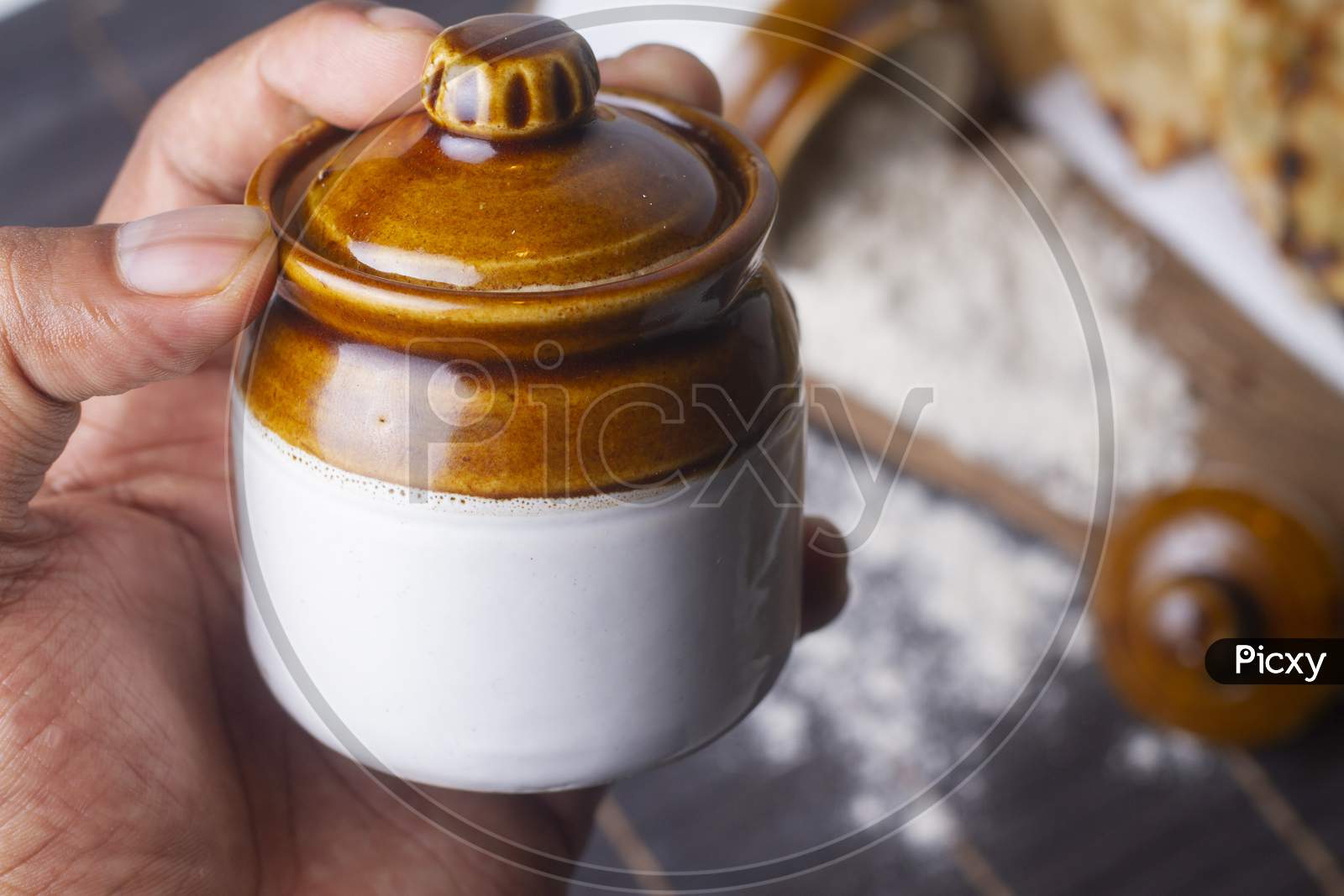 A Jar In Hand Isolated On Light Background.
