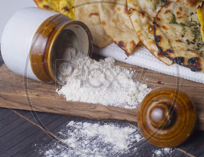 Jar With Flour Spilled On Wooden Background