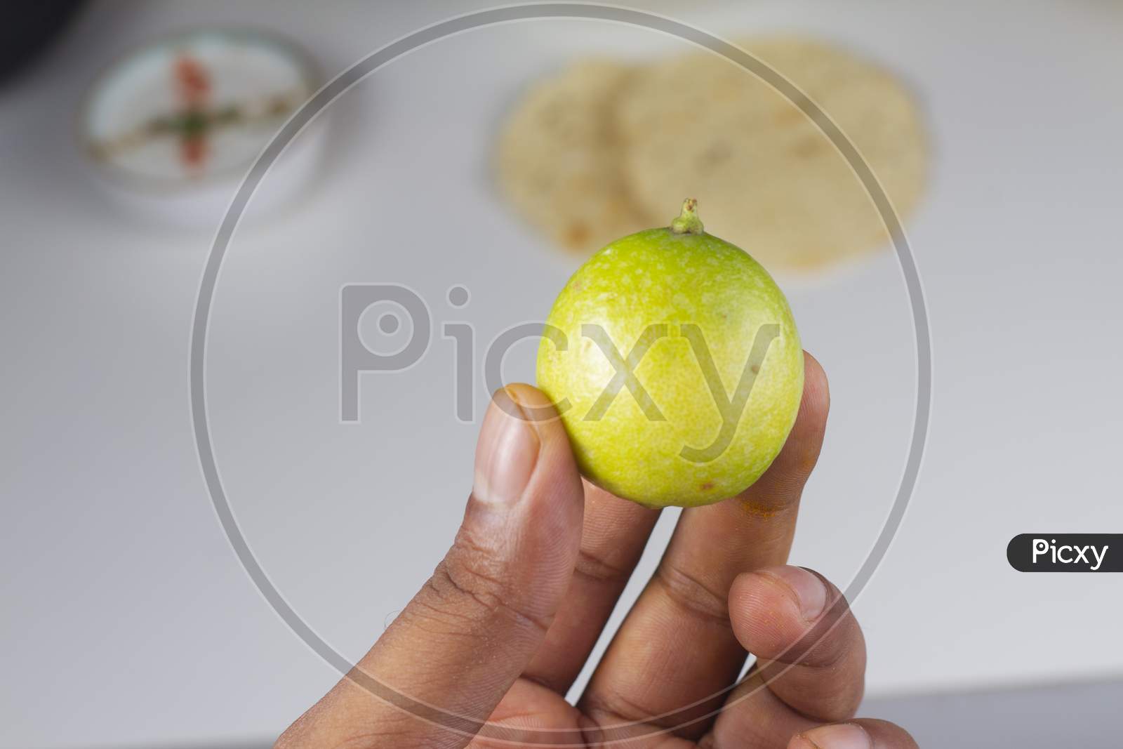 A Person Holding A Lemon In Hand Isolated On Light Background Stock Photo.