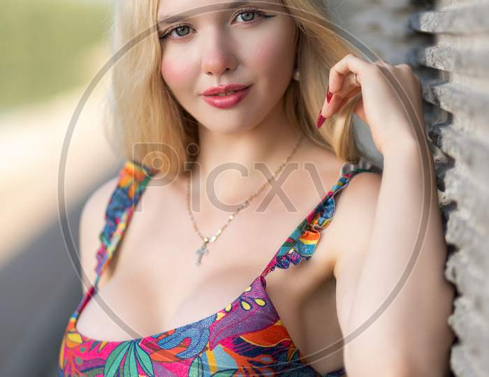 Beautiful Woman With Healthy Body Wearing In A Colotful Swimsuit   Ander Wall.The Concept Of Summer Fashion Swimsuit And Relaxation