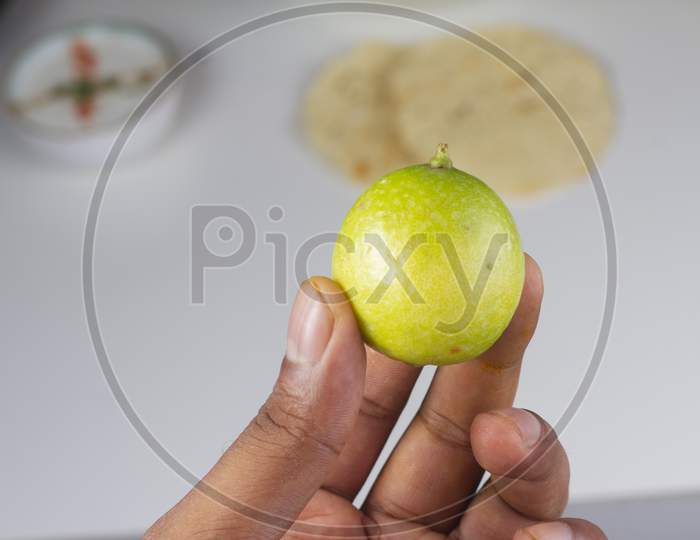 A Person Holding A Lemon In Hand Isolated On Light Background Stock Photo.