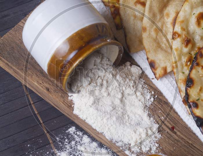 Jar With Flour Spilled On Wooden Background