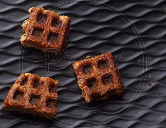 Chocolate Crispy Waffles Pieces On Black Background