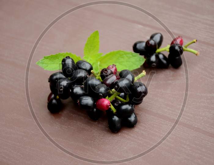 Closeup Blackberry Fruit With Green Mint Over Out Of Focus Brown Background.