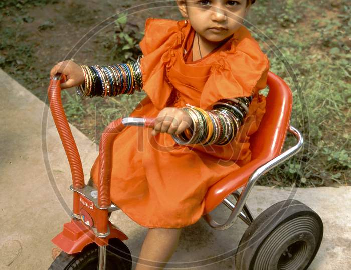 Baby, Bangles And Tricycle