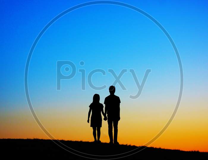 Two People Standing On The Hill