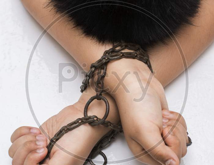 Hand Of A Child Tied Up With Chain On A White Background. Child Trafficking Concept.