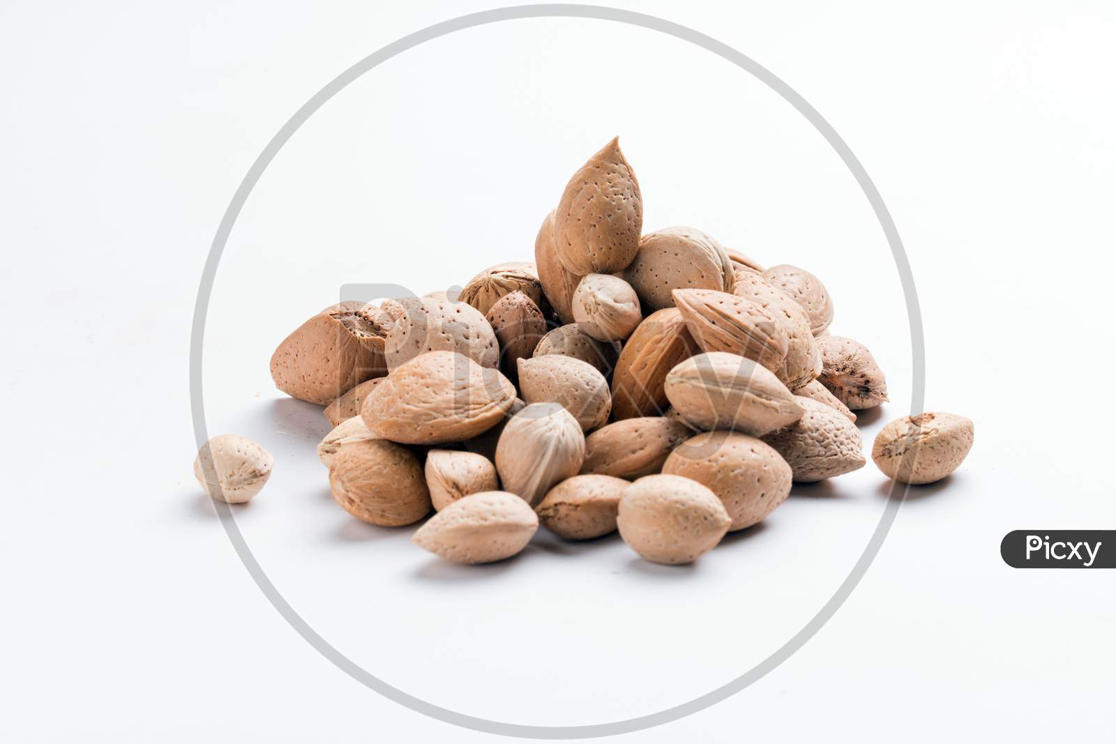 Almonds With Shell, Prunus Amygdalus Heaped On White Background