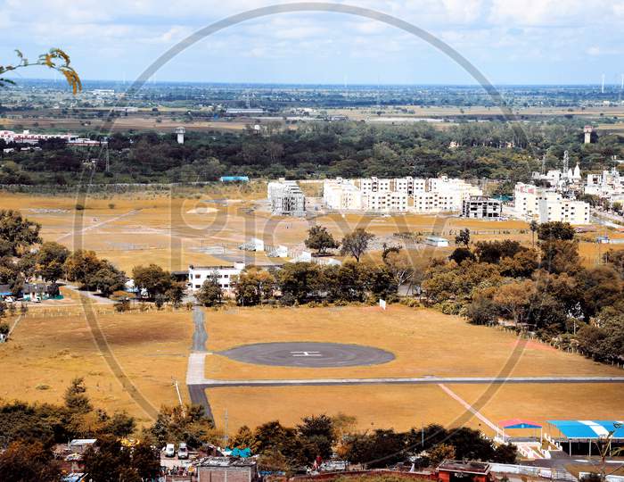 The View Of The City Of Dewas Taken From The Top Of The Hill Is A Helipad In The Middle Of The Ground