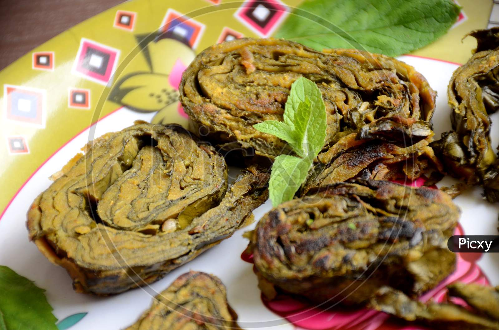 Closeup The Fried Arabic Leaves Food With Green Mint In The Plate Over Out Of Focus White Pink Background.