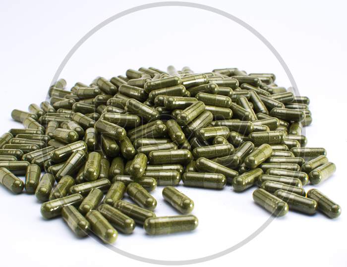 Green powdered herbal substance in a soft gel capsule