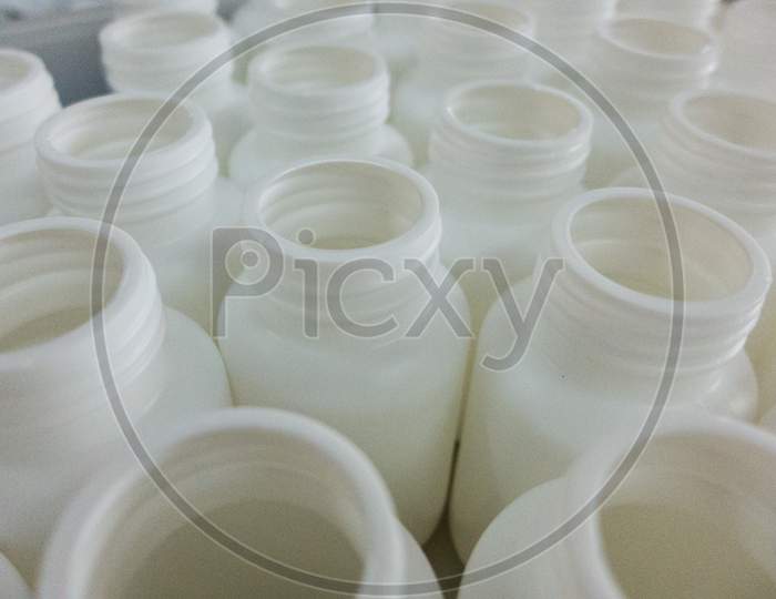 Empty white medical plastic bottles for production
