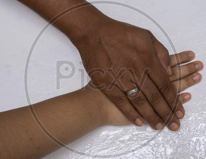A Male Hand Holding A Child Hand To Give Him Support. Selective Focus.