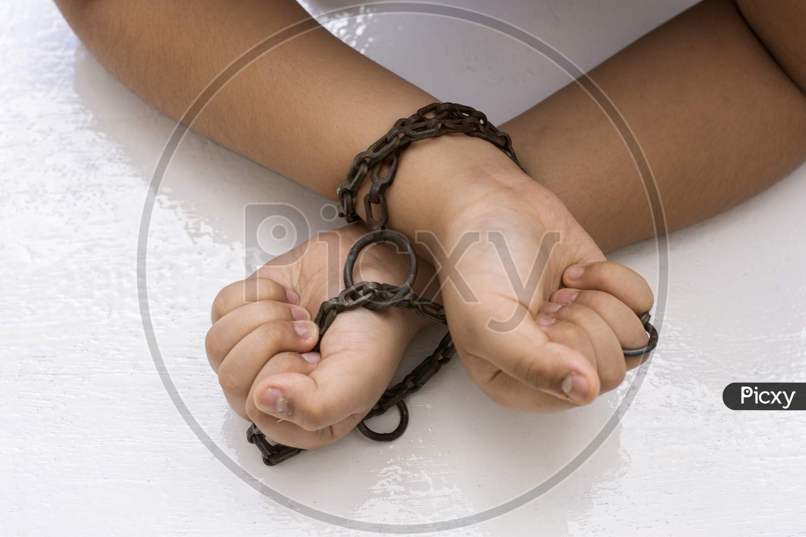 Hand Of A Child Tied Up With Chain On A White Background. Child Trafficking Concept.