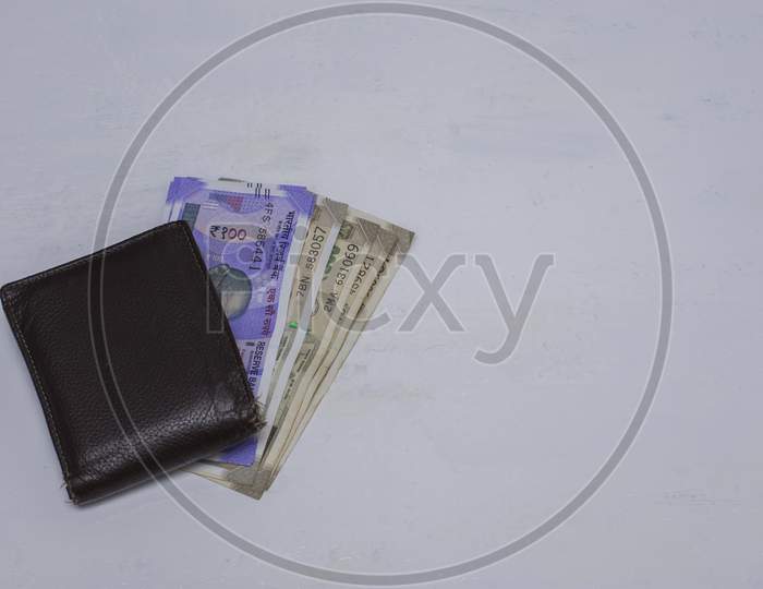 A Wallet With Money And Credit Cards On A White Surface.