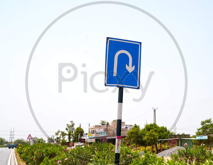Traffic Sign Right U Turn Sign On Pole With Blue Background Sign Board. Traffic Signs And Symbols Concept.