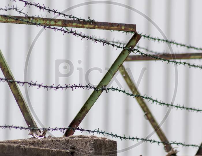 Barbed wire fence as protection and no trespassing safety symbol and warning for defense and military razor sharp security for jail and imprisonment of criminals and secure border line fixation in war