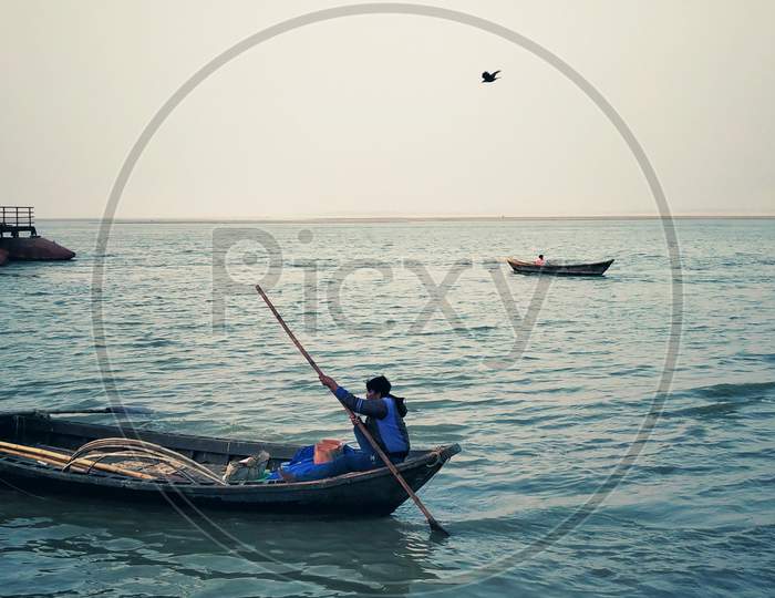 Fisherman Rowing His Boat On Ganga River
