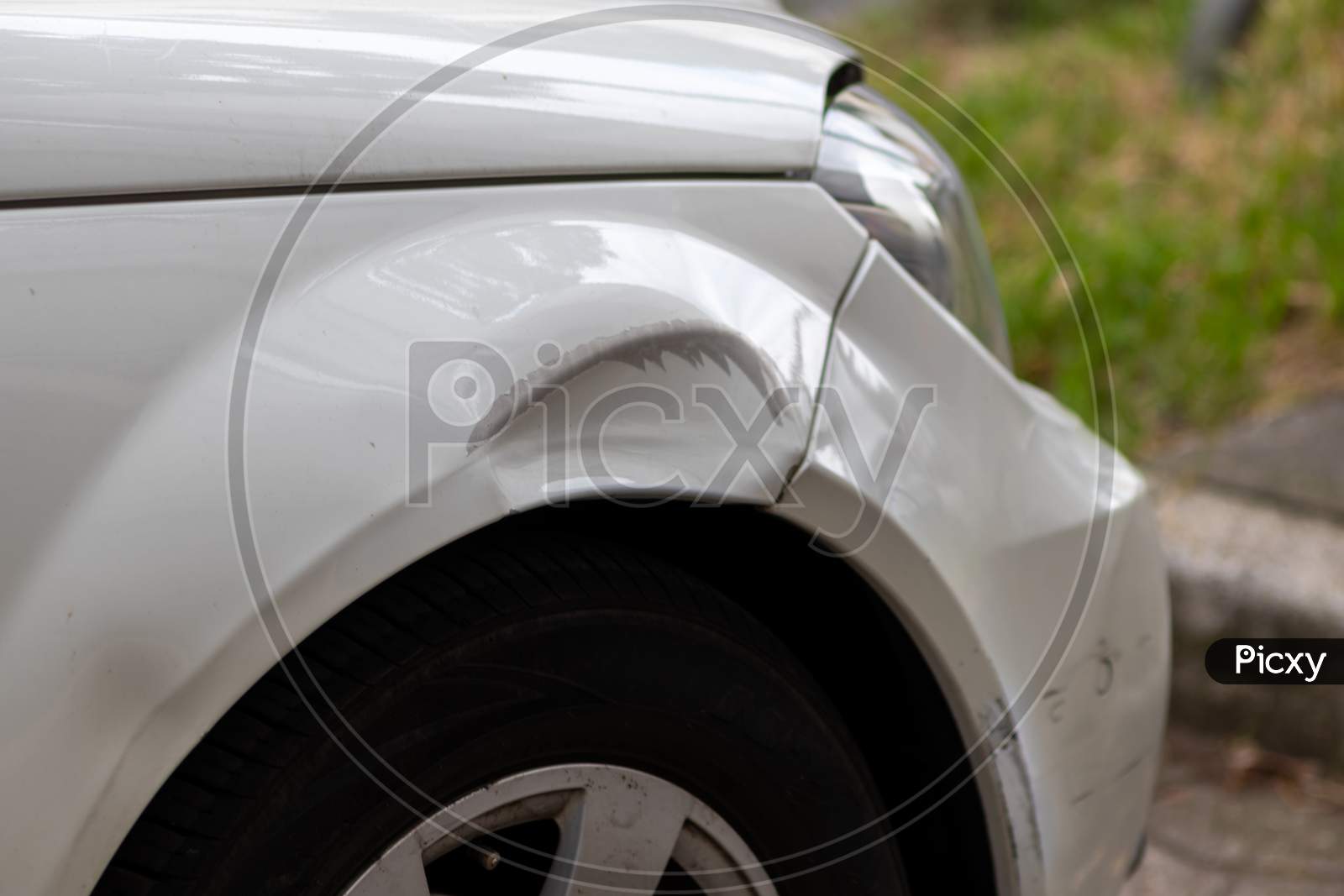 Dented car wing and fender with scratches and bumps after crash and car accident with hit-and-run driving and absconding shows need for car insurance and safety protection and mechanics garage service