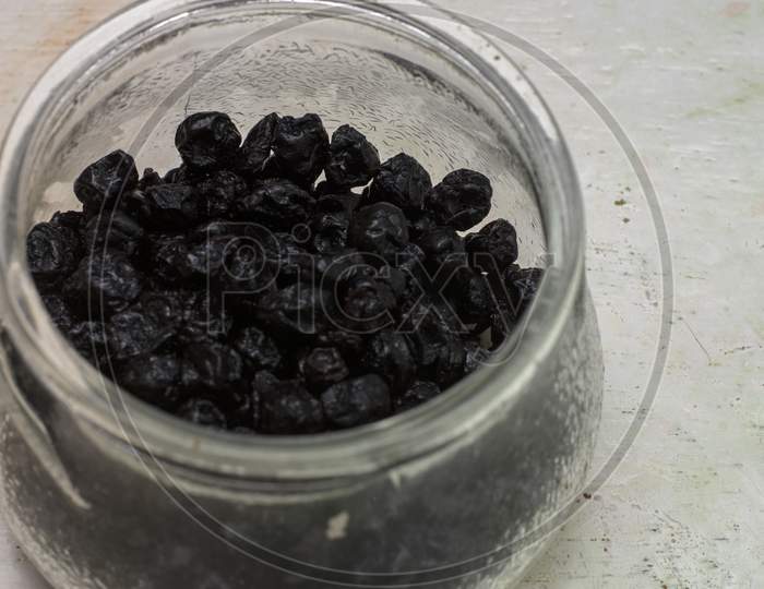 Dried Organic Blue Berries In A Jar On A White Background With Selective Focus