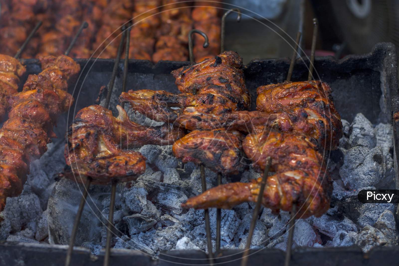 Tasty Chicken Wings On Grill With Fire. Selective Focus