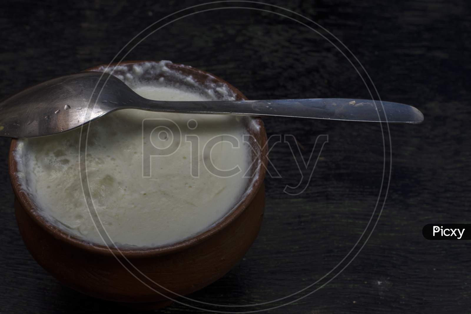 A Clay Pot Full Of Delicious Curd With Spoon. Selective Focus
