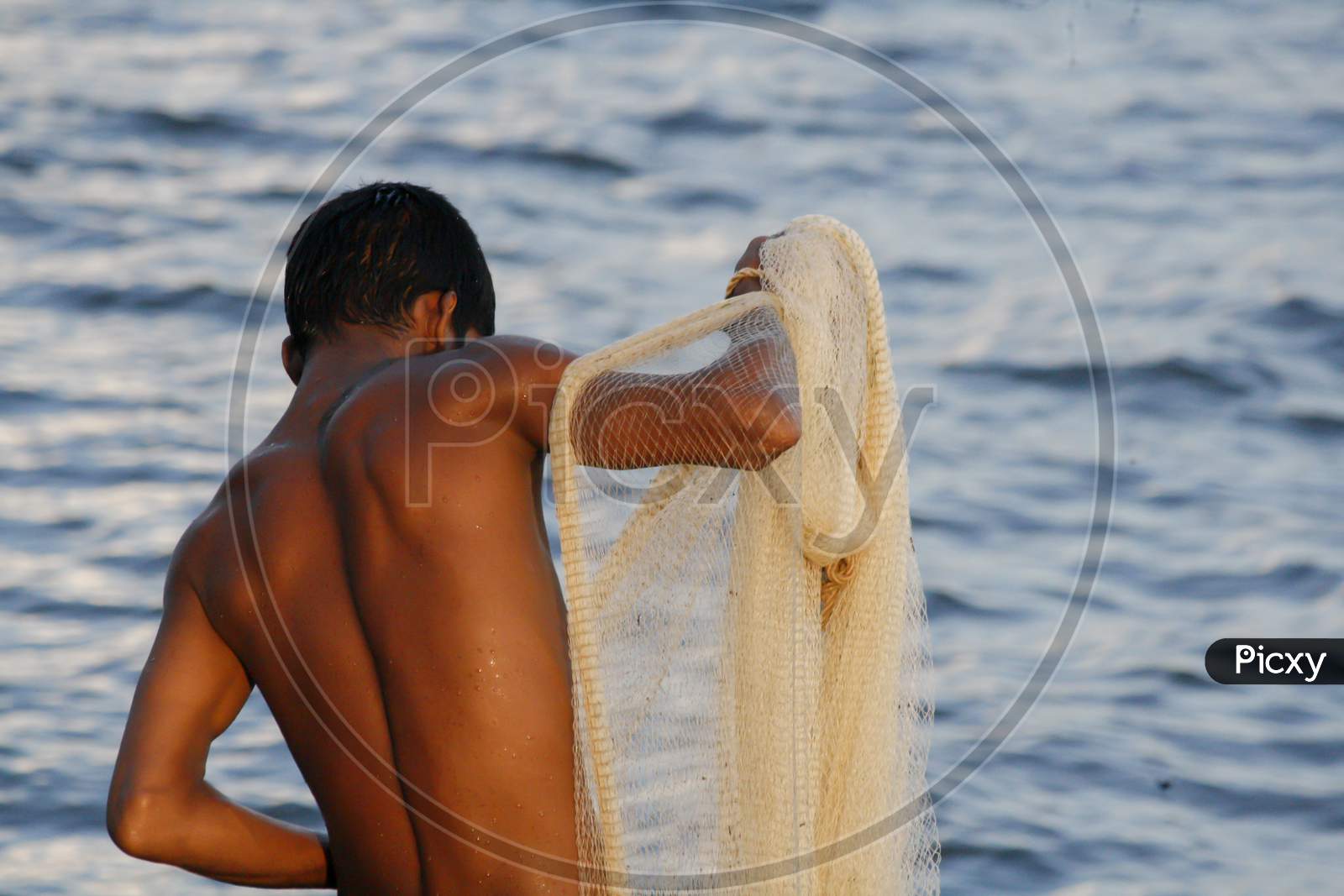 Image of A fisherman preparing his fishing net to catch fish on