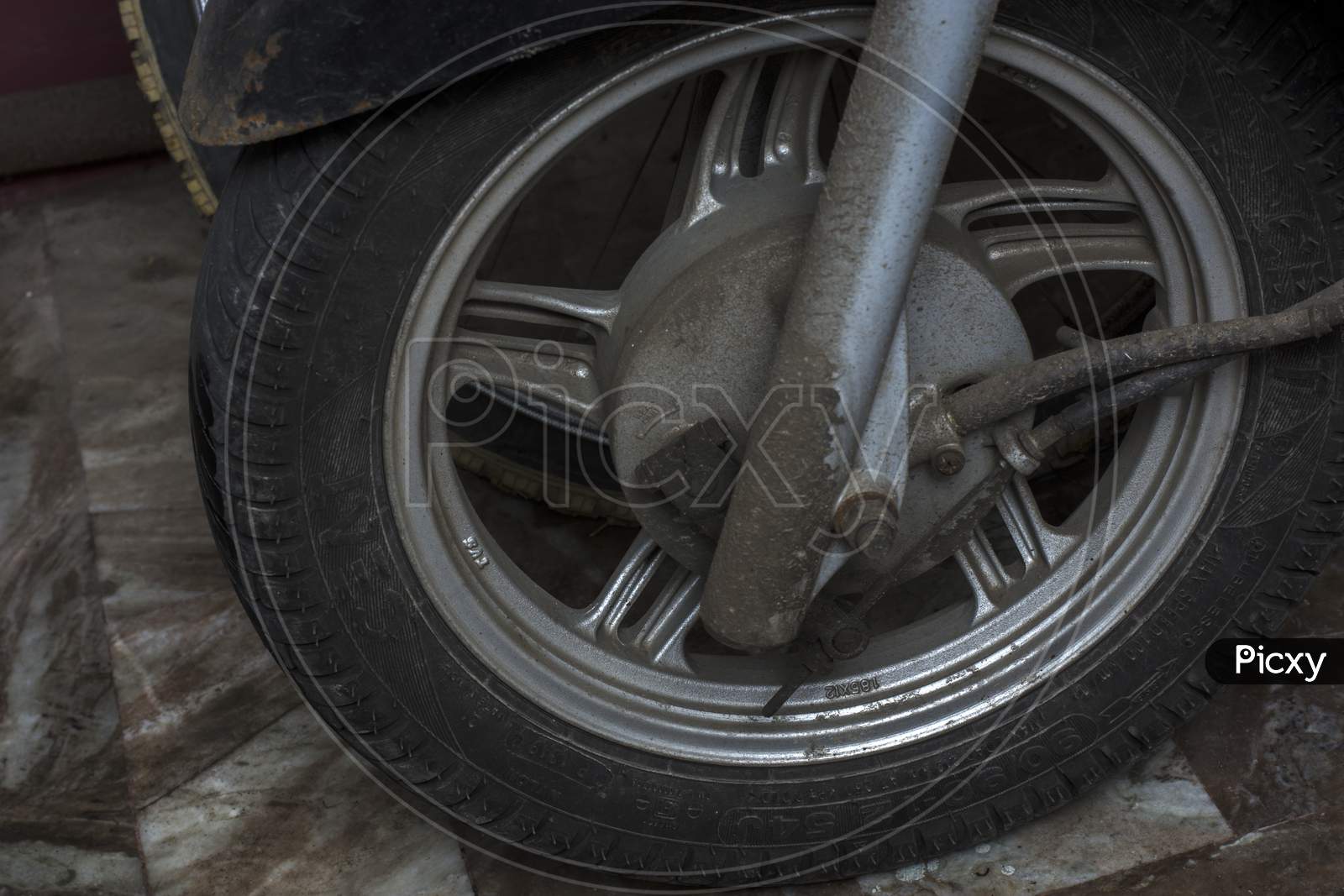 Front Wheel Of A Scooter With Lots Of Dust And Mud