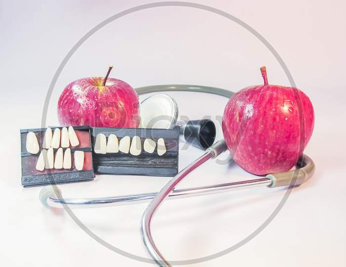 Two Apples A Stethoscope And Artificial Teeth.Dental Health.
