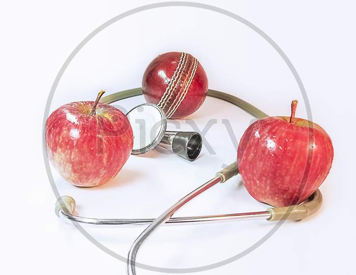 Two Apples A Stethoscope And A Deuce Ball.Health For Sports .