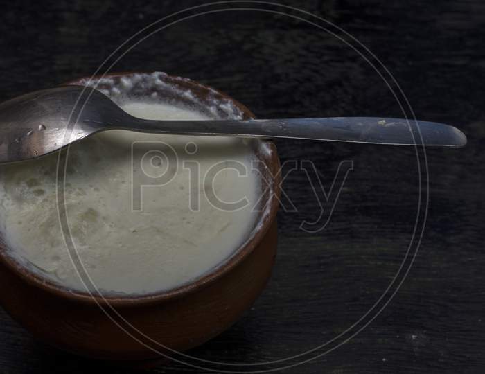 A Clay Pot Full Of Delicious Curd With Spoon. Selective Focus