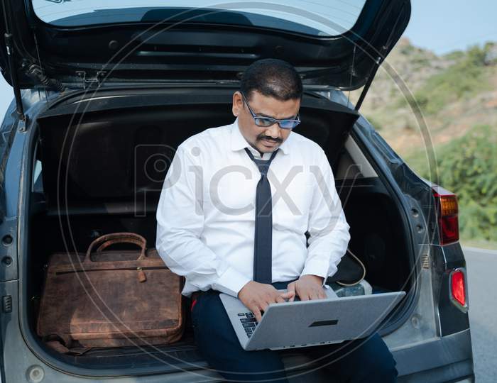 Young Businessman Working From The Car Trunk Or Boot Near Roadside - Concept Of Digital Nomadic Lifestyle, Travel Freelancer And Vacations.
