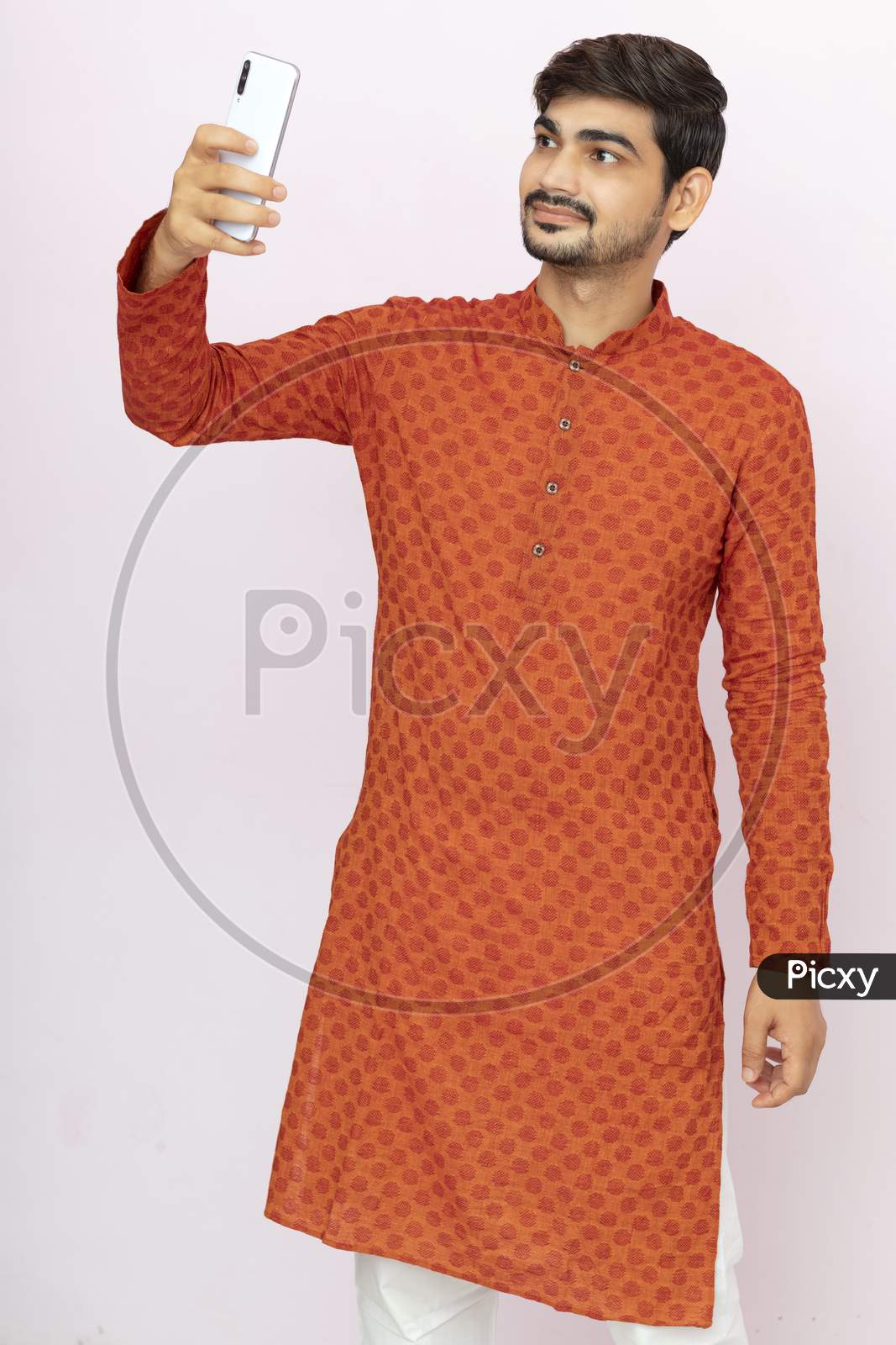 Young Indian Man In Ethnic Wear Taking Selfie With Mobile Phone.