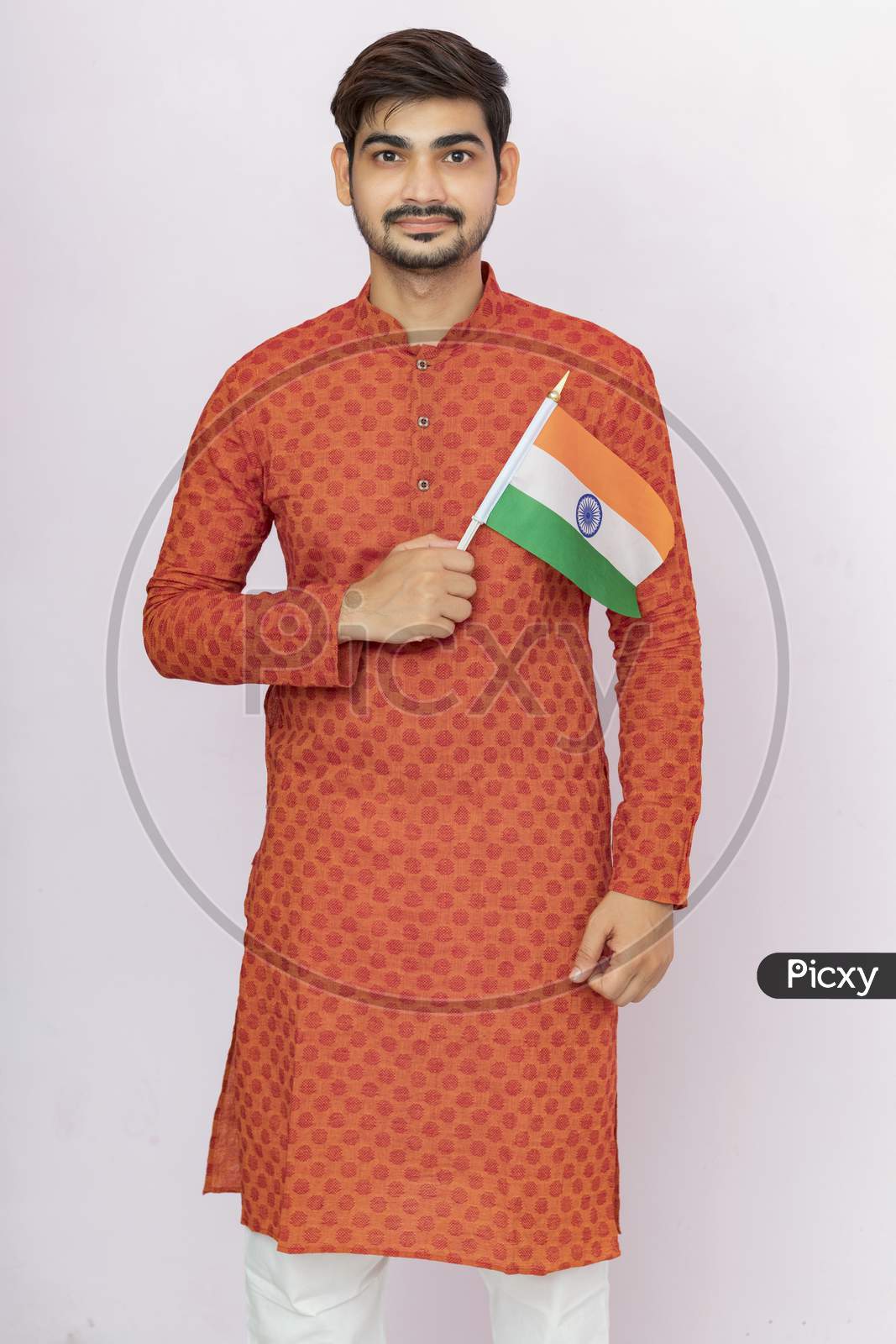 Handsome Indian Boy Or Man In Ethnic Wear  Holding Indian National Flag And Showing Patriotism, Standing Isolated Background.