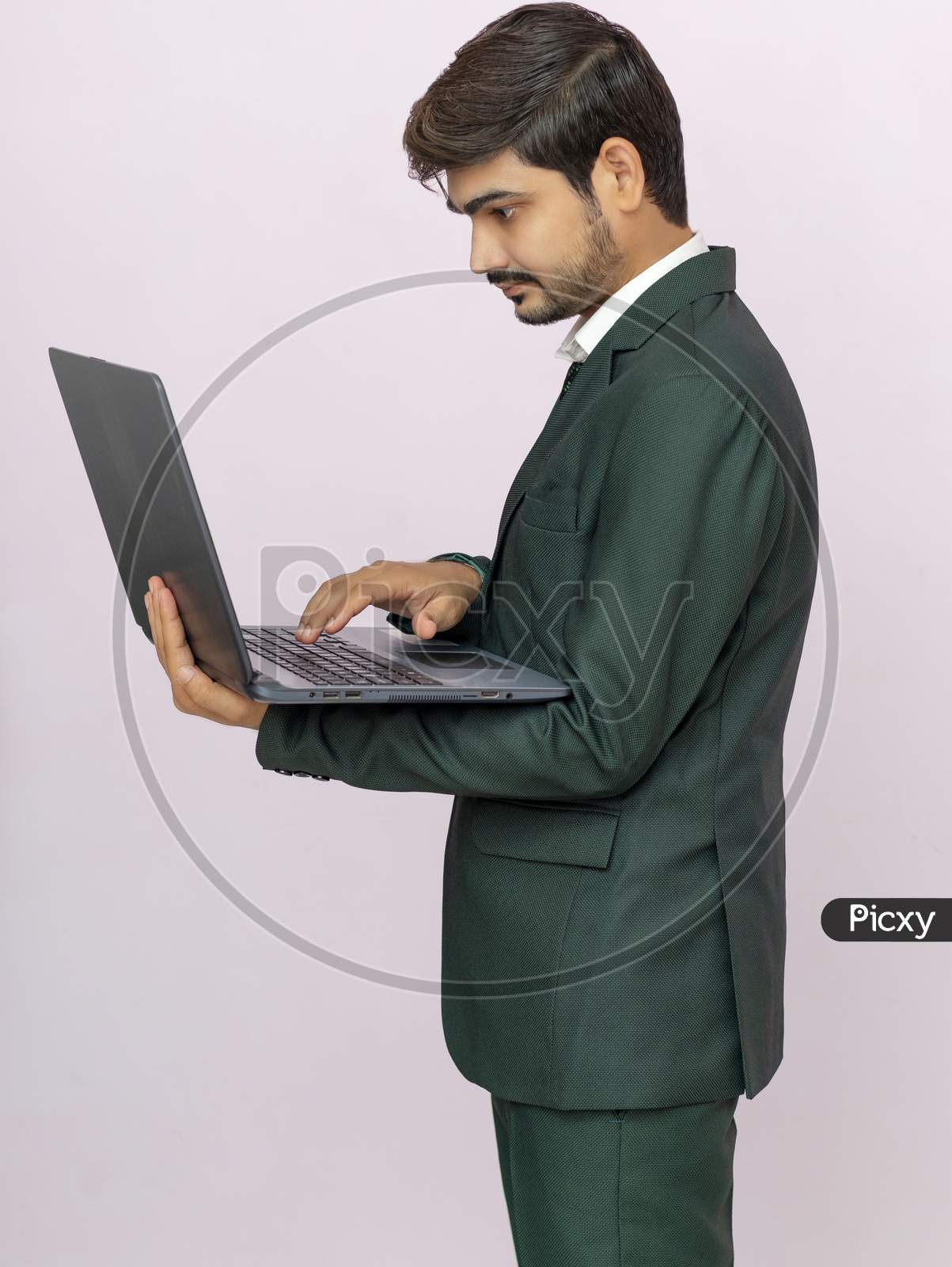 Photo Of Thoughtful Focused Clever Interested Freelancer Holding Laptop With Hands  Working On Deadline Project Isolated Background.
