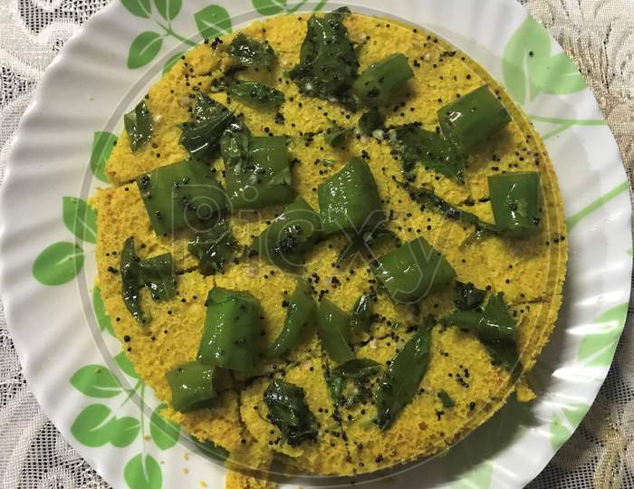 A picture of a freshly cooked famous Gujarati Dish, Khaman Dhokla, which is ready to serve.