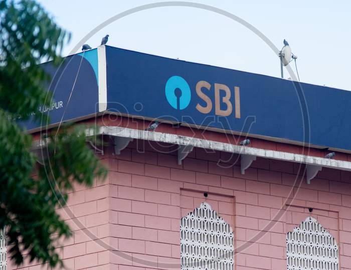 Blue State Bank Of India Sbi Board Hoarding On Top Of Pink Building Showing India'S Largest Public Sector Bank Under Which Psu Banks Are Being Consolidated